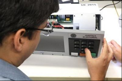 homem verifica urna eletrônica